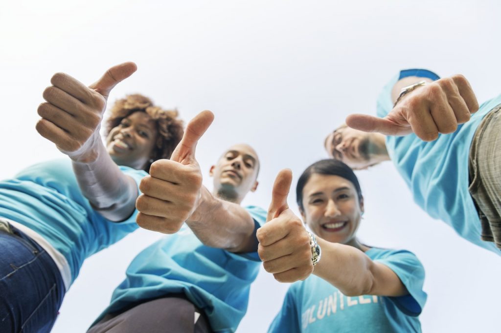 Four People Looking Down And Showing Thumb Up Gesture