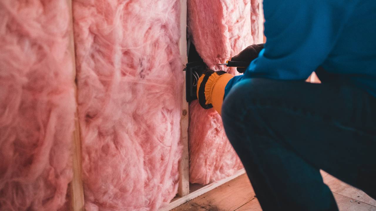 Qualified handyman works on a type of pink insulation