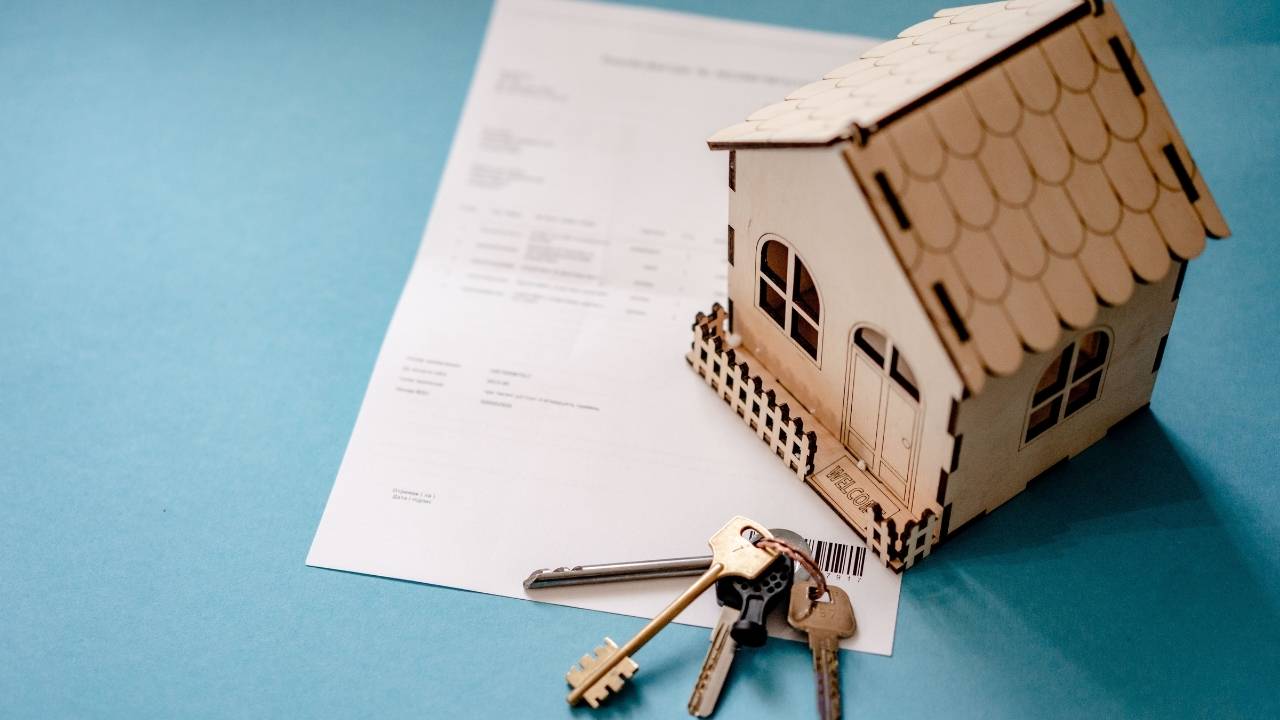 A miniature house and keys on a piece of paper